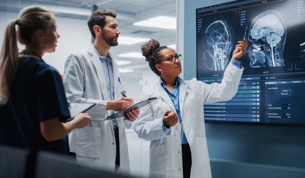 Healthcare professionals analyzing real-time clinical data on a high-tech digital monitor for QMSR compliance.